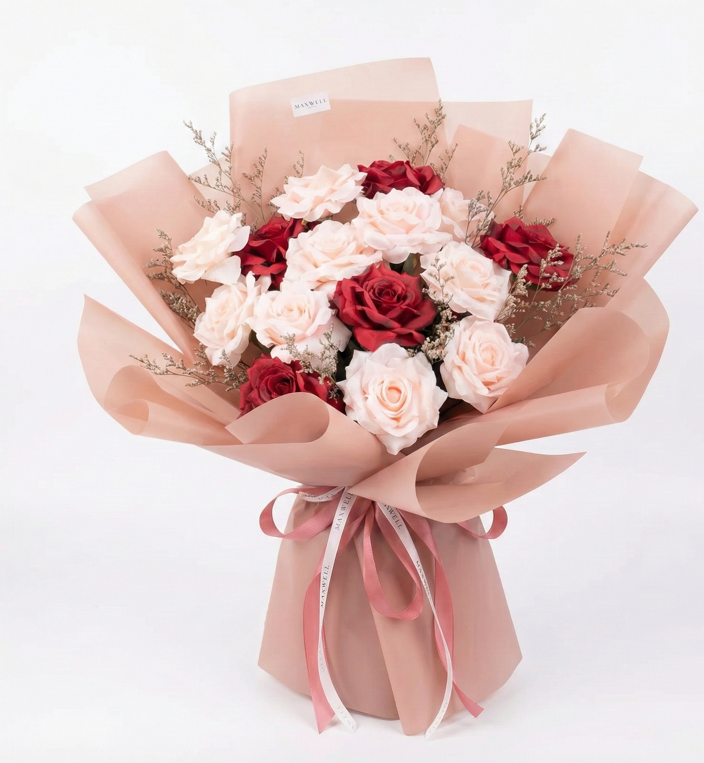 Bouquet of red and white flowers wrapped in brown paper on a white background
