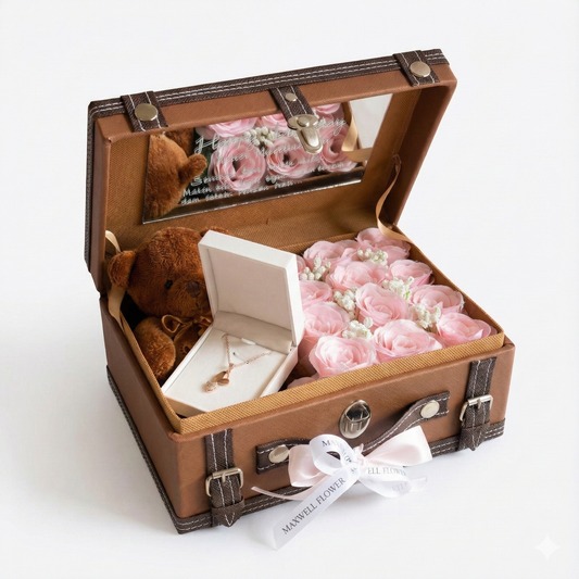 Open brown suitcase with pink flowers and a teddy bear on a white background