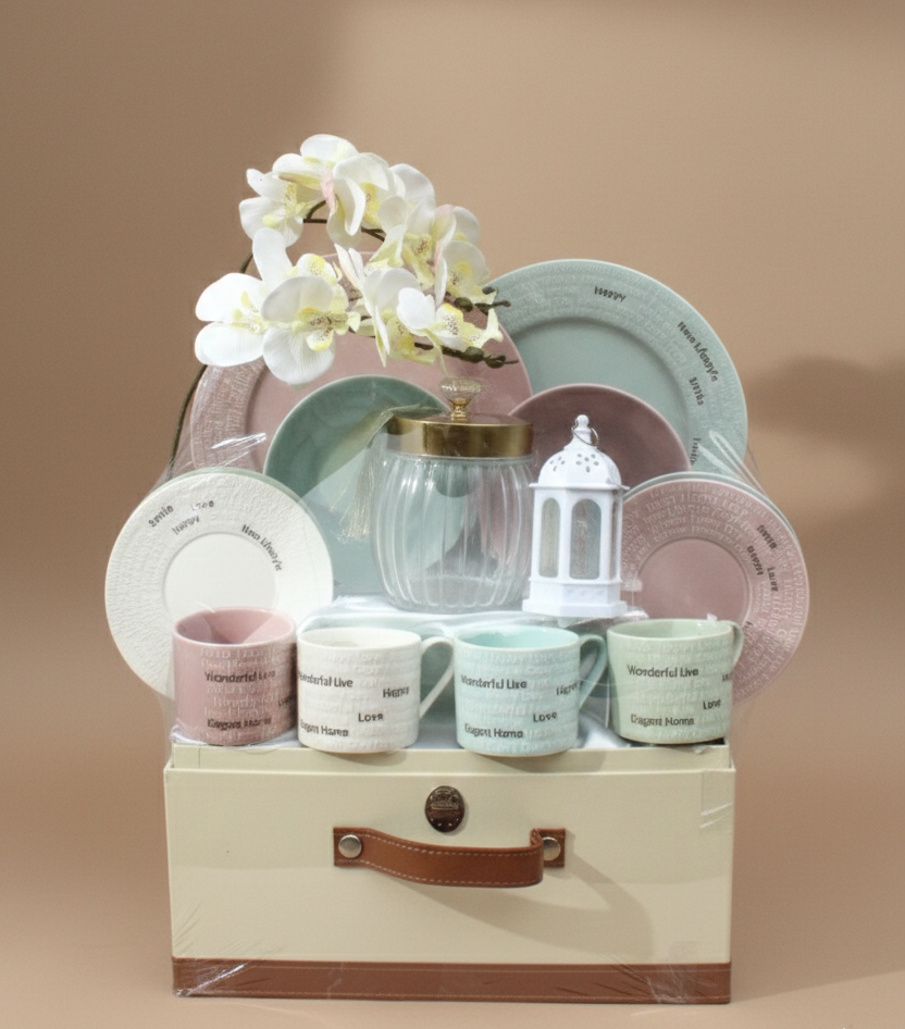 Set of ceramic tableware including plates, cups, and a lantern on a beige stand with a white flower arrangement against a beige background.