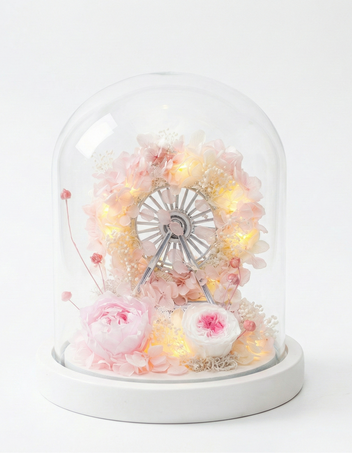 Decorative glass dome with fairy lights and flowers on a white background