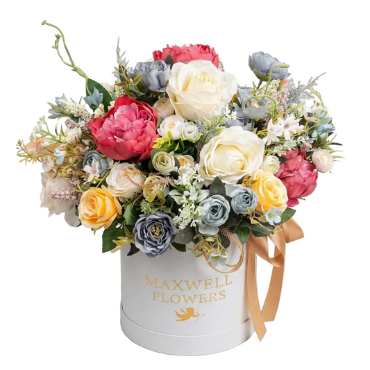 Colorful flower arrangement in a white box with 'Maxwell Flowers' branding on a light gray background